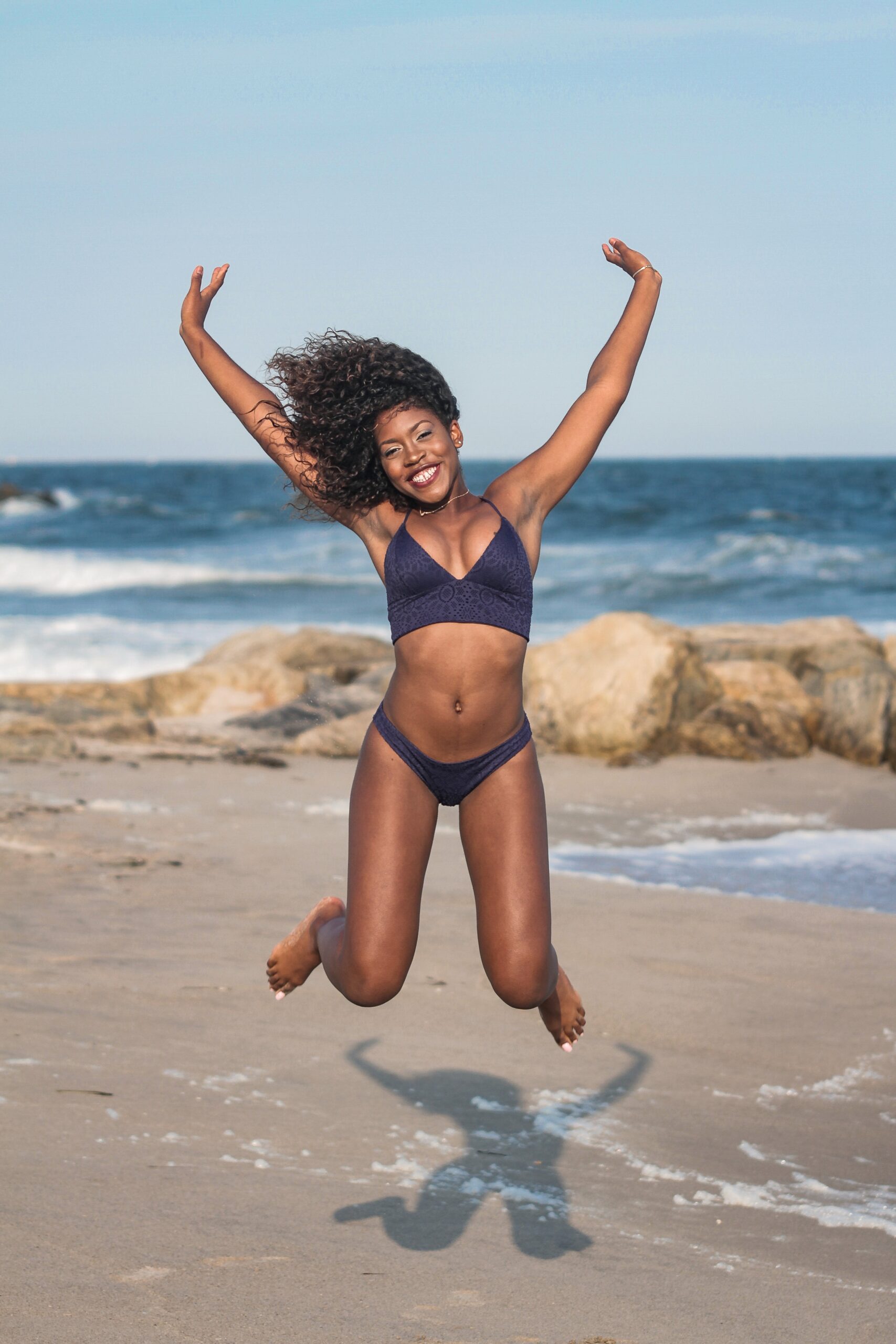 Young black woman jumping in air- Anti aging and body sculpting with Dr. Farah Sultan